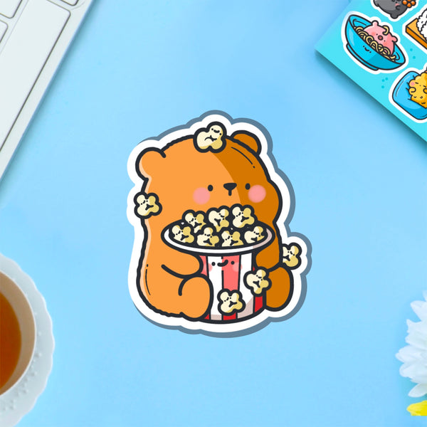 Bear with popcorn vinyl sticker on blue table