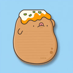 A cute potato-shaped notepad with a smiling face, topped with white cream and green toppings, shown on a light blue background.