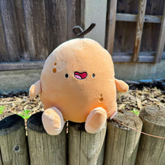 Potato plush sat on a fence