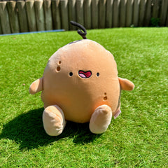 Potato plush toy on green grass