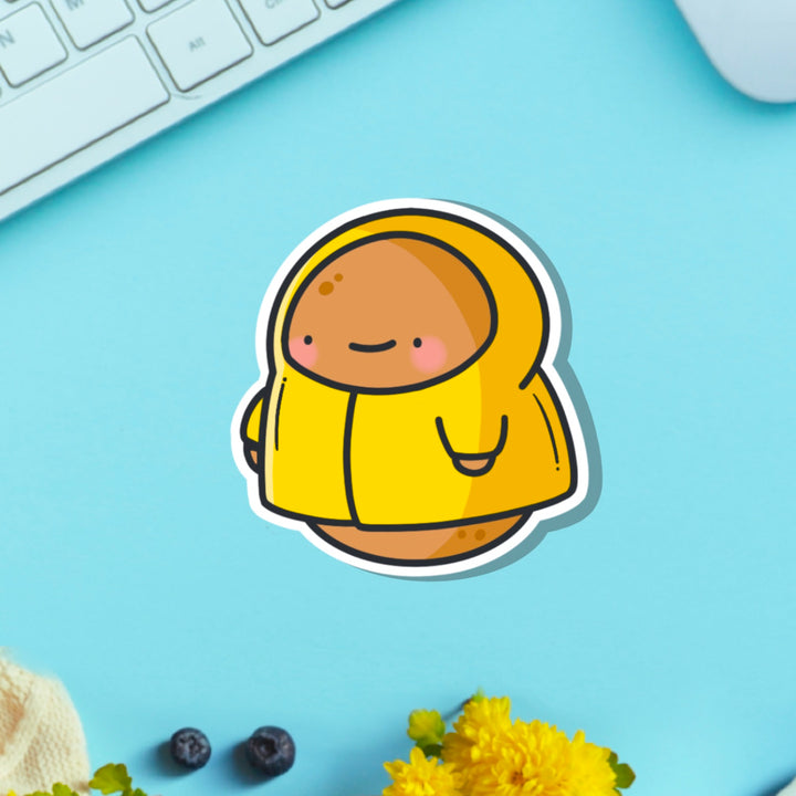 Potato in a raincoat vinyl sticker on blue table with keyboard