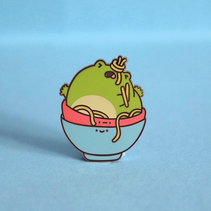 Frog in a bowl enamel pin on blue background