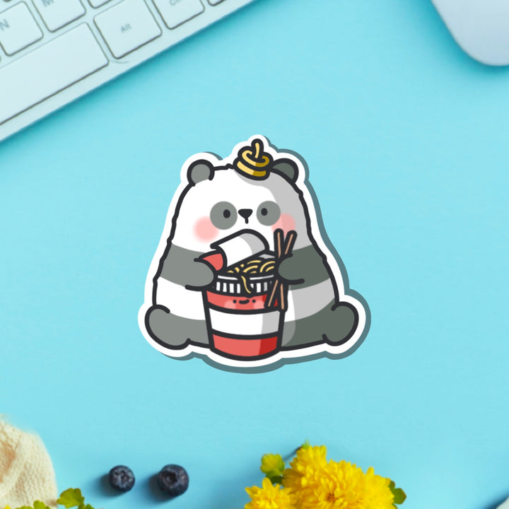 Panda holding ramen vinyl sticker on green table