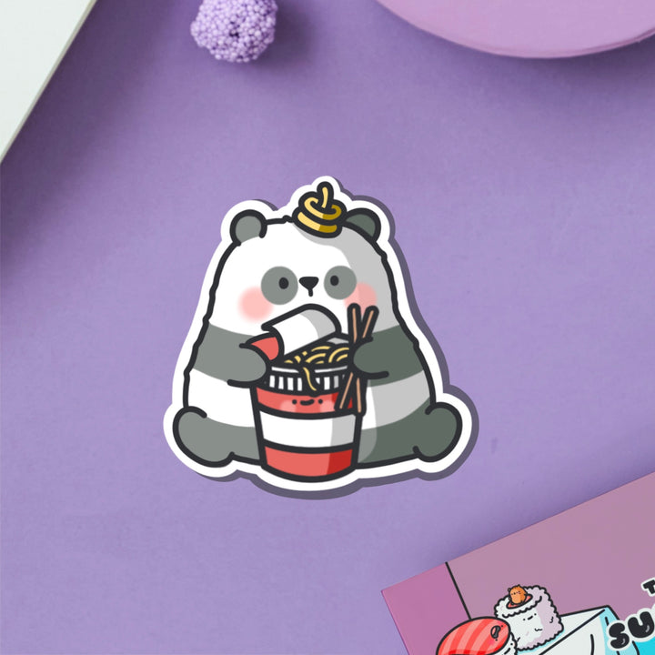 Panda holding ramen vinyl sticker on purple table