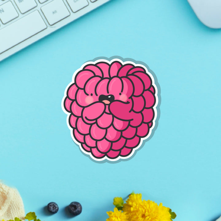 Raspberry vinyl sticker on blue table with keyboard