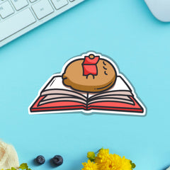 Reading potato vinyl sticker on blue table with keyboard