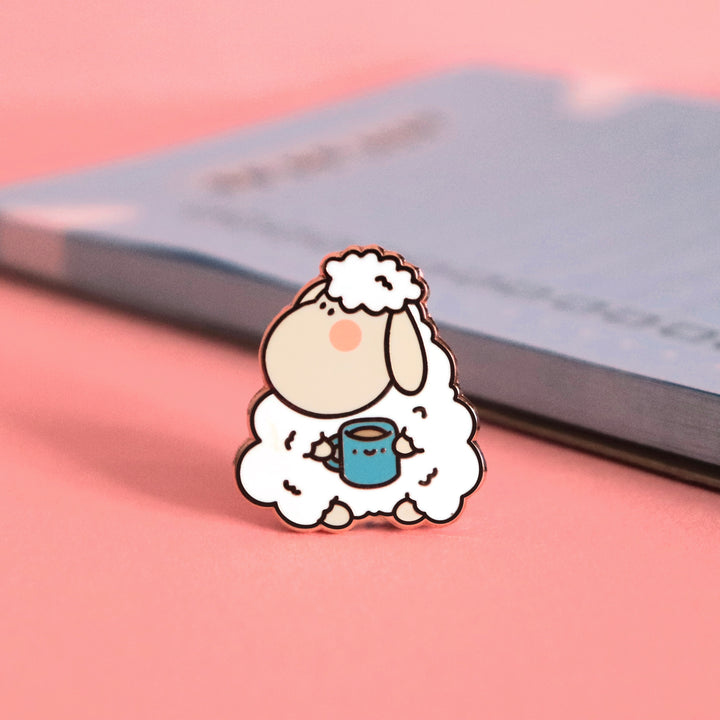 Sheep enamel pin on pink table with notepad