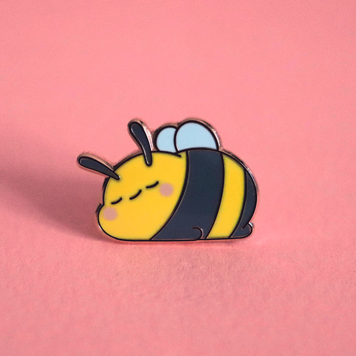 Sleeping bee enamel pin on pink table