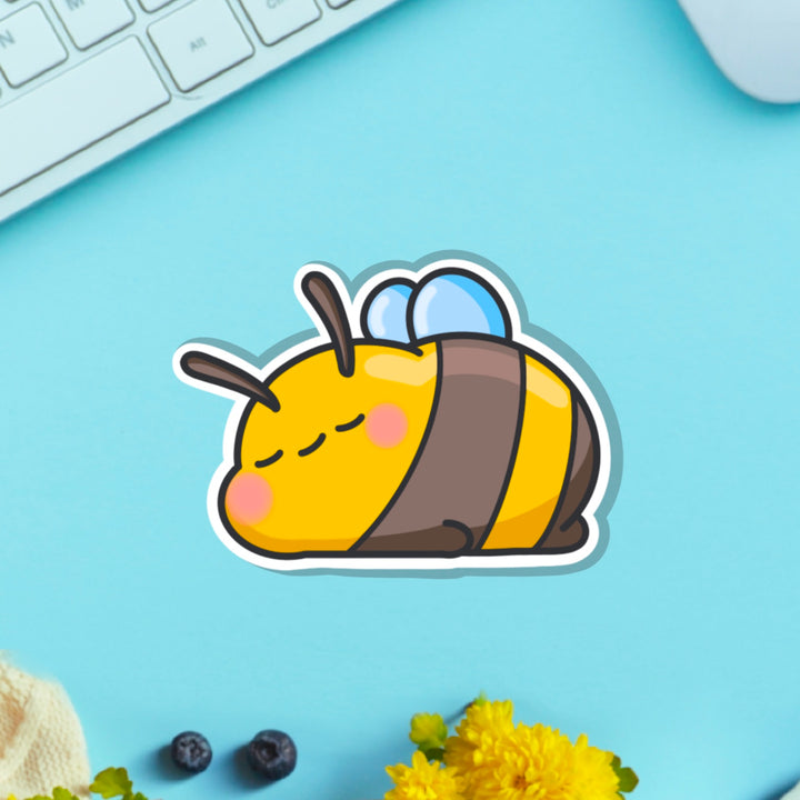 Sleepy Bee vinyl sticker on blue table with keyboard