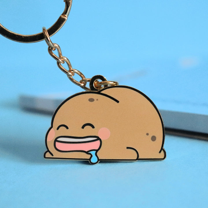Potato keyring on blue table with notepad