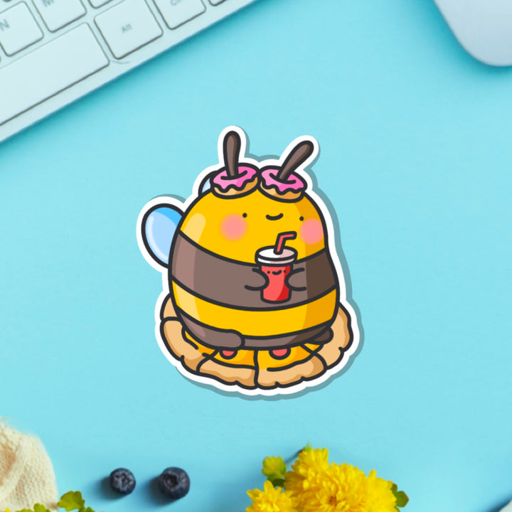 Snacking bee vinyl sticker on blue table with keyboard