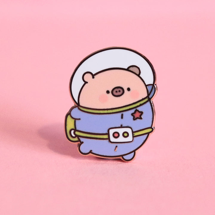 Space Pig enamel pin on pink desk