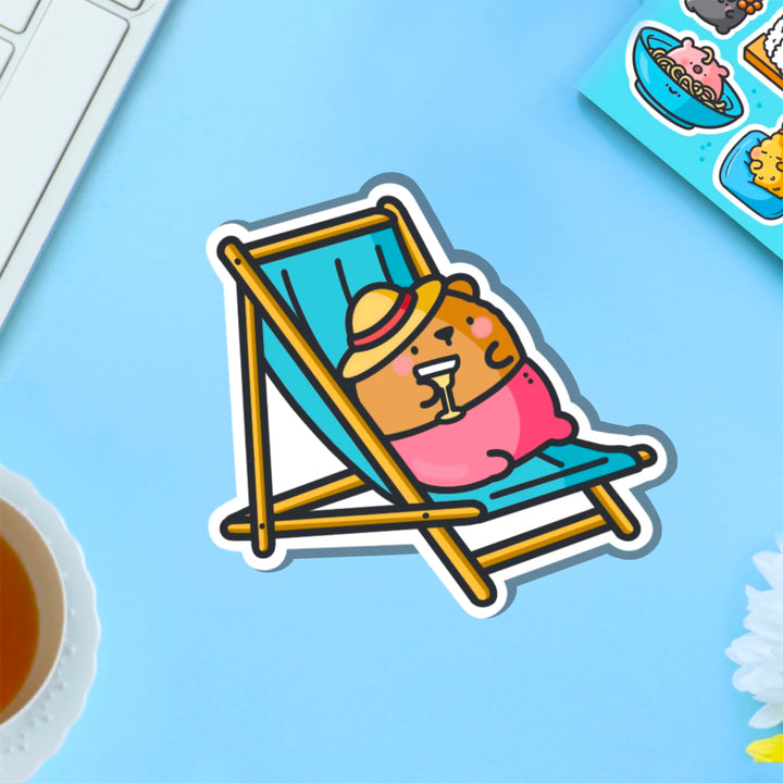 Bear sunbathing vinyl sticker on blue table