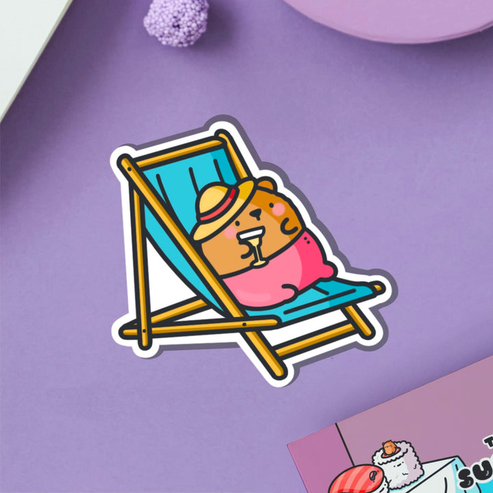 Bear sunbathing vinyl sticker on purple table