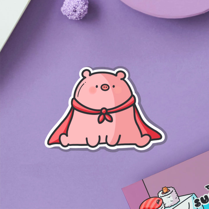 Super pig in red cape vinyl sticker on purple table