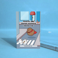 Super potato in red cape enamel pin on street backing card
