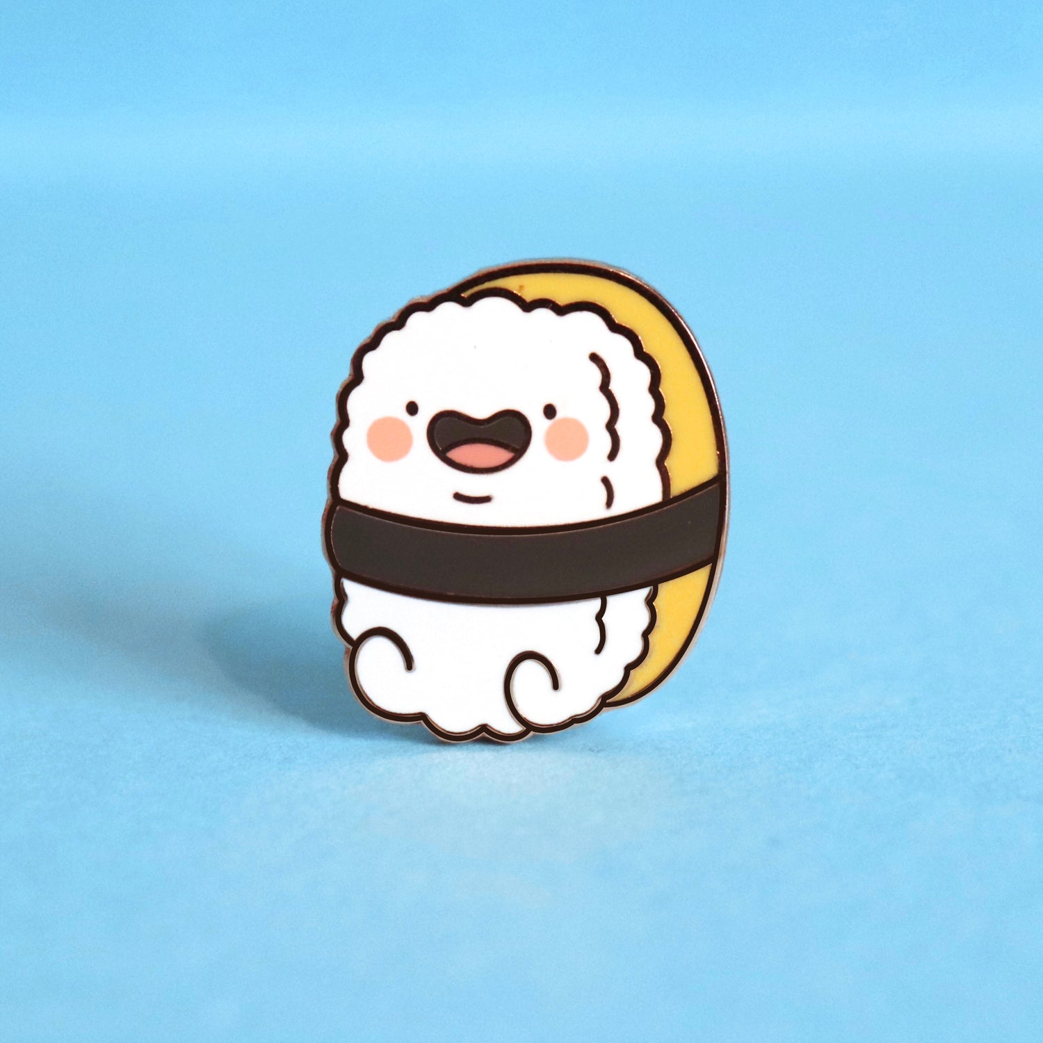Sushi enamel pin on blue table