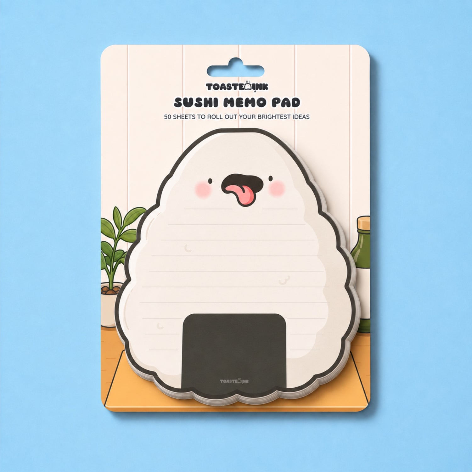 A packaged Toastink Sushi Memo Pad featuring a cute onigiri (rice ball) design with a pink tongue and cheeks, set against a light blue background.