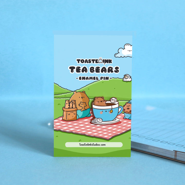 Bear sat in a cup of tea enamel pin on picnic backing card