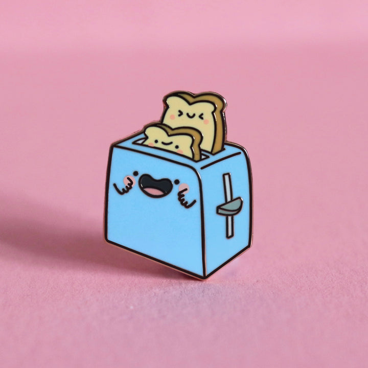 Toaster enamel pin on pink desk