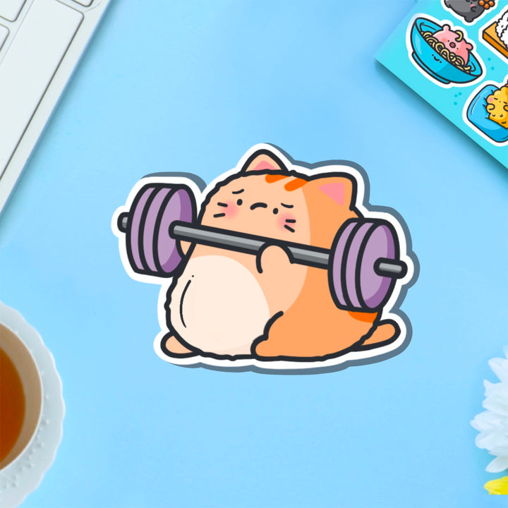 Cat lifting weights vinyl sticker on blue table