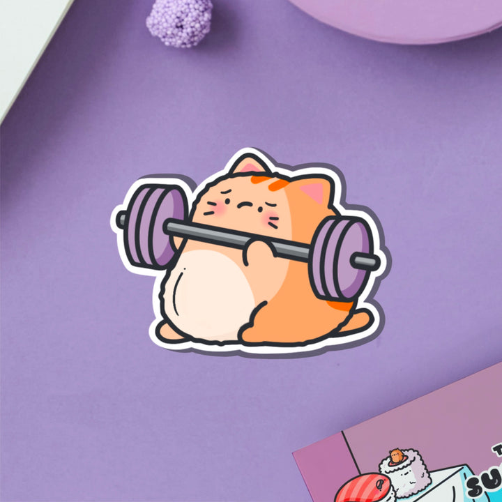 Cat lifting weights vinyl sticker on purple table