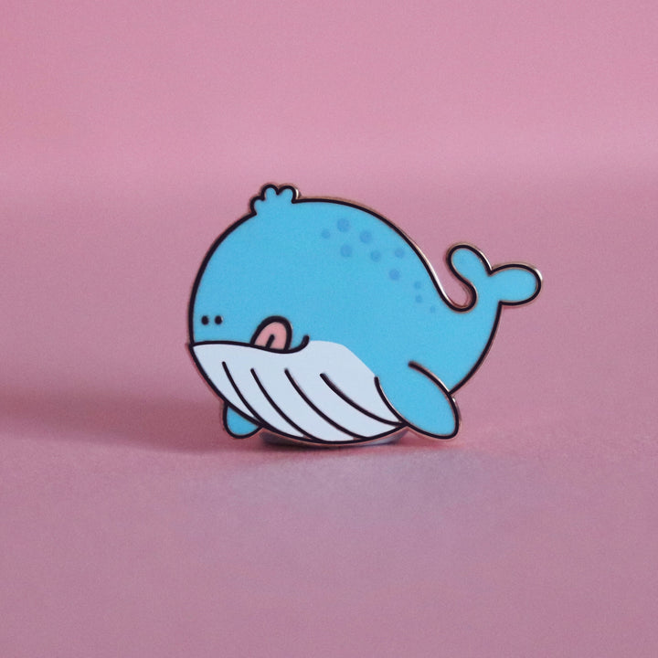 Whale enamel pin on pink desk