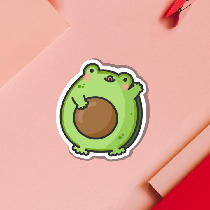 Frog as avocado vinyl sticker on pink table