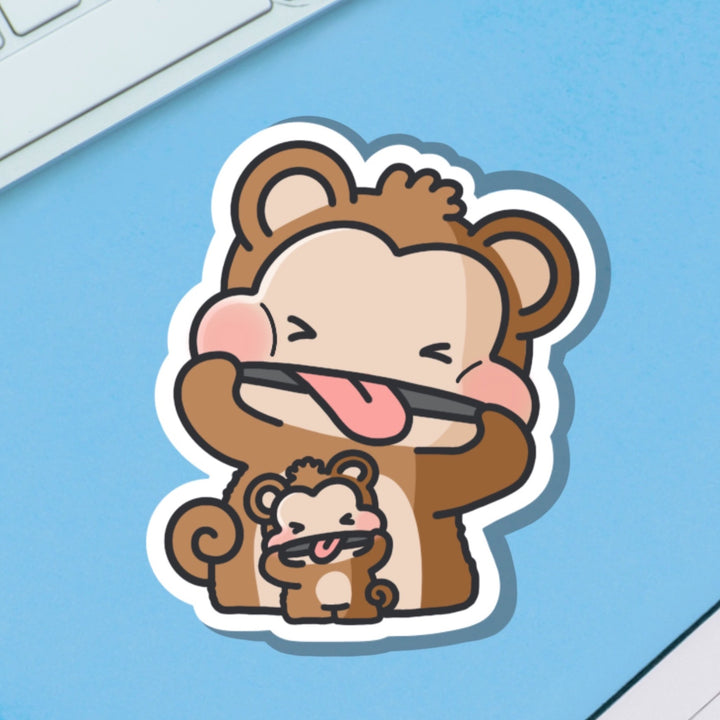 Monkey pulling cheeky face vinyl sticker on blue background