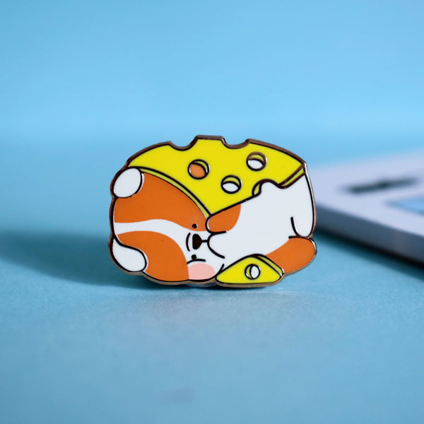 Cheese dog enamel pin on blue table