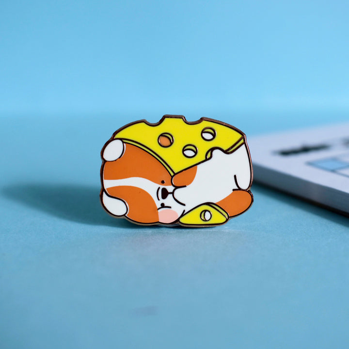 Cheese dog enamel pin on blue table