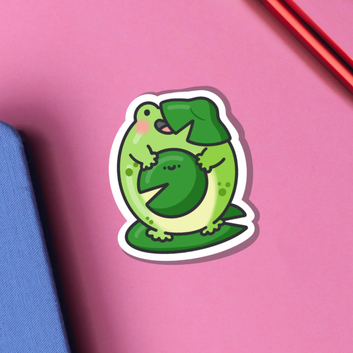 Frog on water lilies vinyl sticker on pink table with notebook