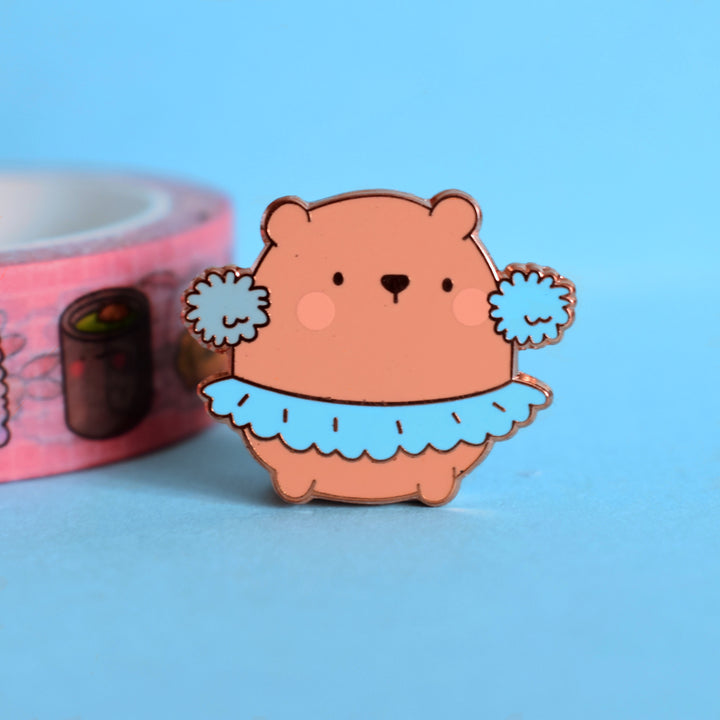 bear enamel pin with washi tape on blue table