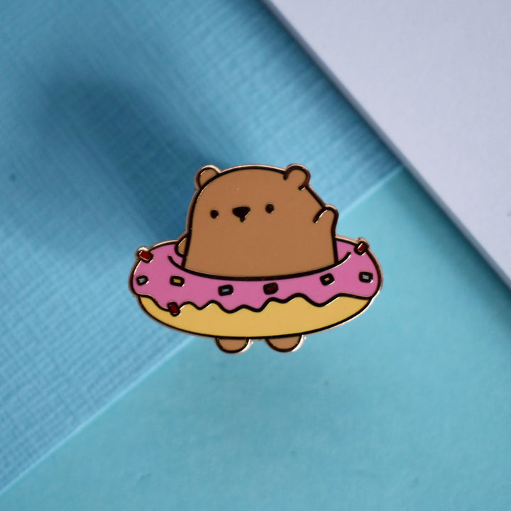 Bear donut enamel pin on blue table