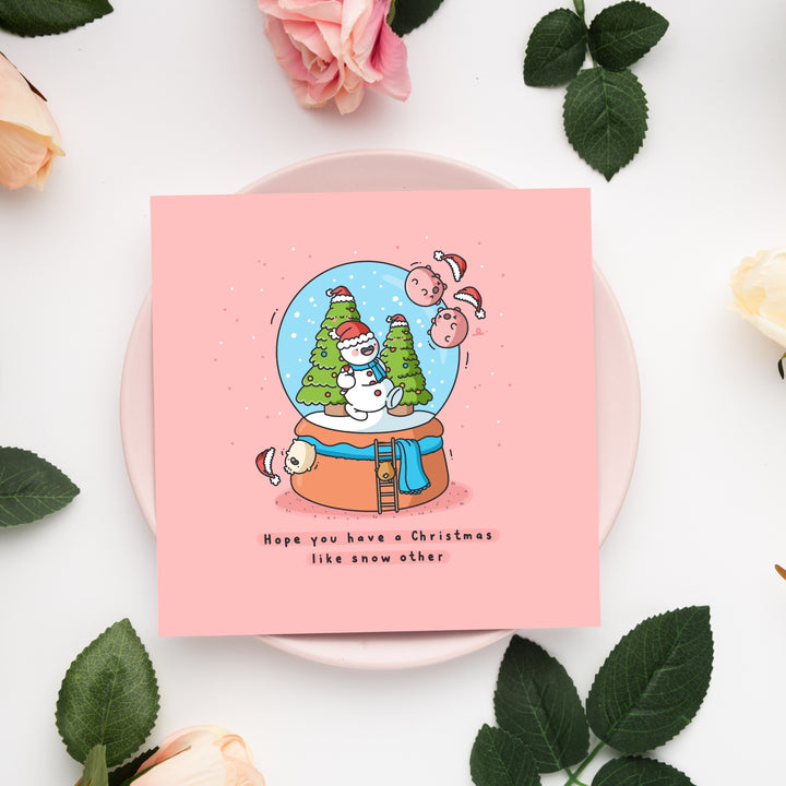 Christmas snowglobe card on pink plate