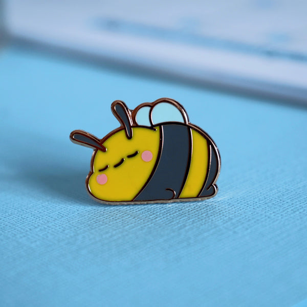 Sleepy bee enamel pin on blue background