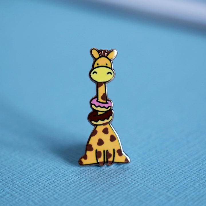 Cute giraffe enamel pin on blue table