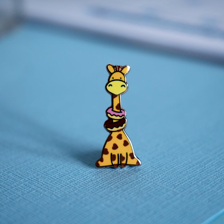 Giraffe enamel pin with notepad on blue background