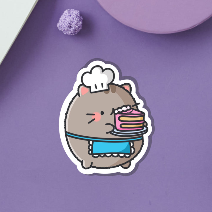 Cat holding cake vinyl sticker on purple table