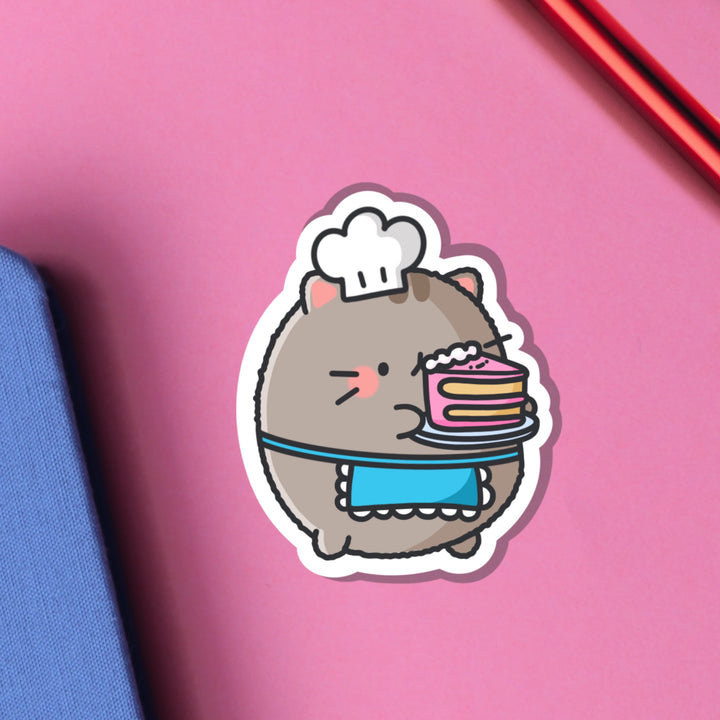 Cat holding cake vinyl sticker on pink table