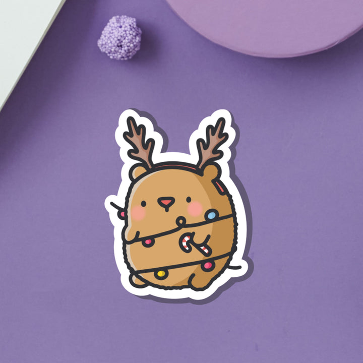 Bear dressed as reindeer vinyl sticker on purple background