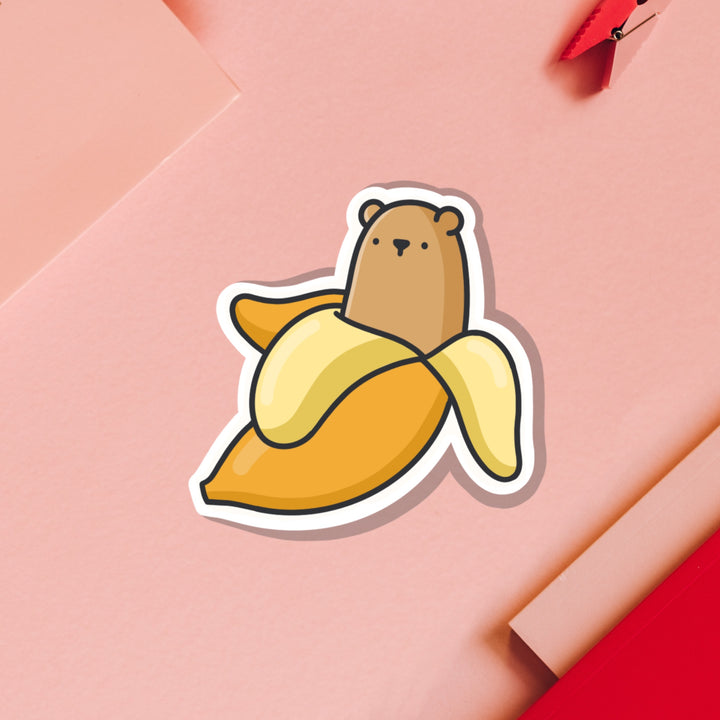 Bear in a banana vinyl sticker on pink table