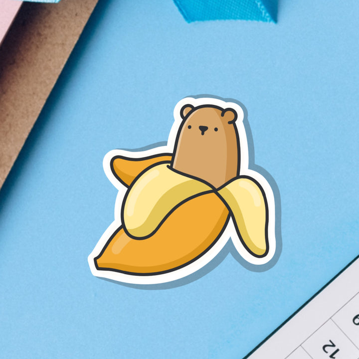 Bear in a banana vinyl sticker on blue table