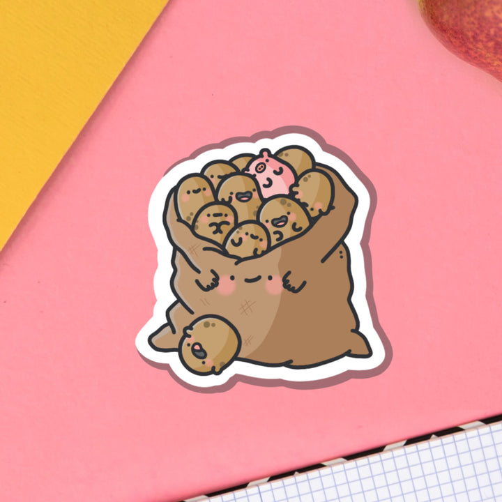 Bag of potatoes vinyl sticker on pink table and notebook