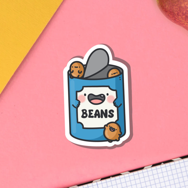 Baked Beans Vinyl Sticker on pink background and notebook
