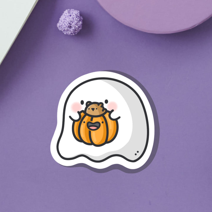 Ghost with pumpkin vinyl sticker on purple desk