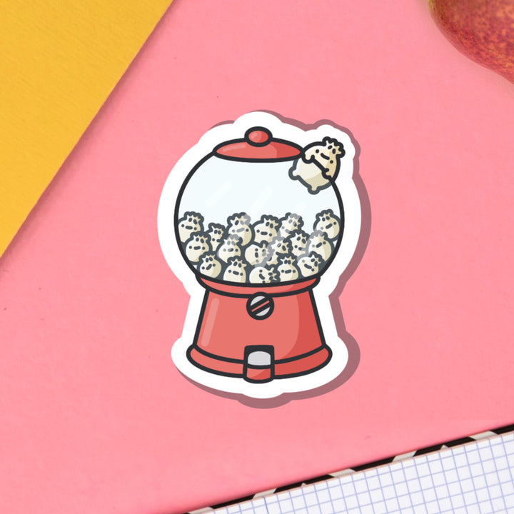 dumplings in a gumball machine vinyl sticker on pink table with notebook