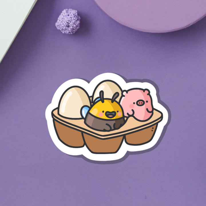 Egg carton with pig and bee vinyl sticker on purple background