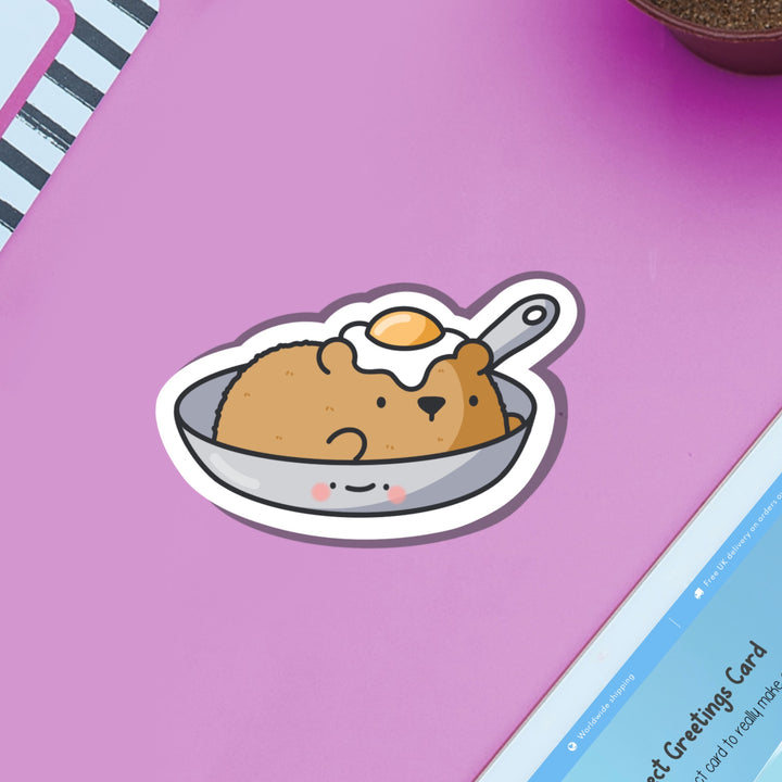 Bear in a frying pan vinyl sticker on purple table and ipad