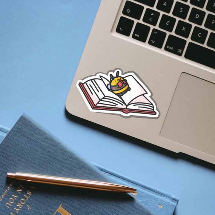 Bee lying on a book vinyl sticker on laptop